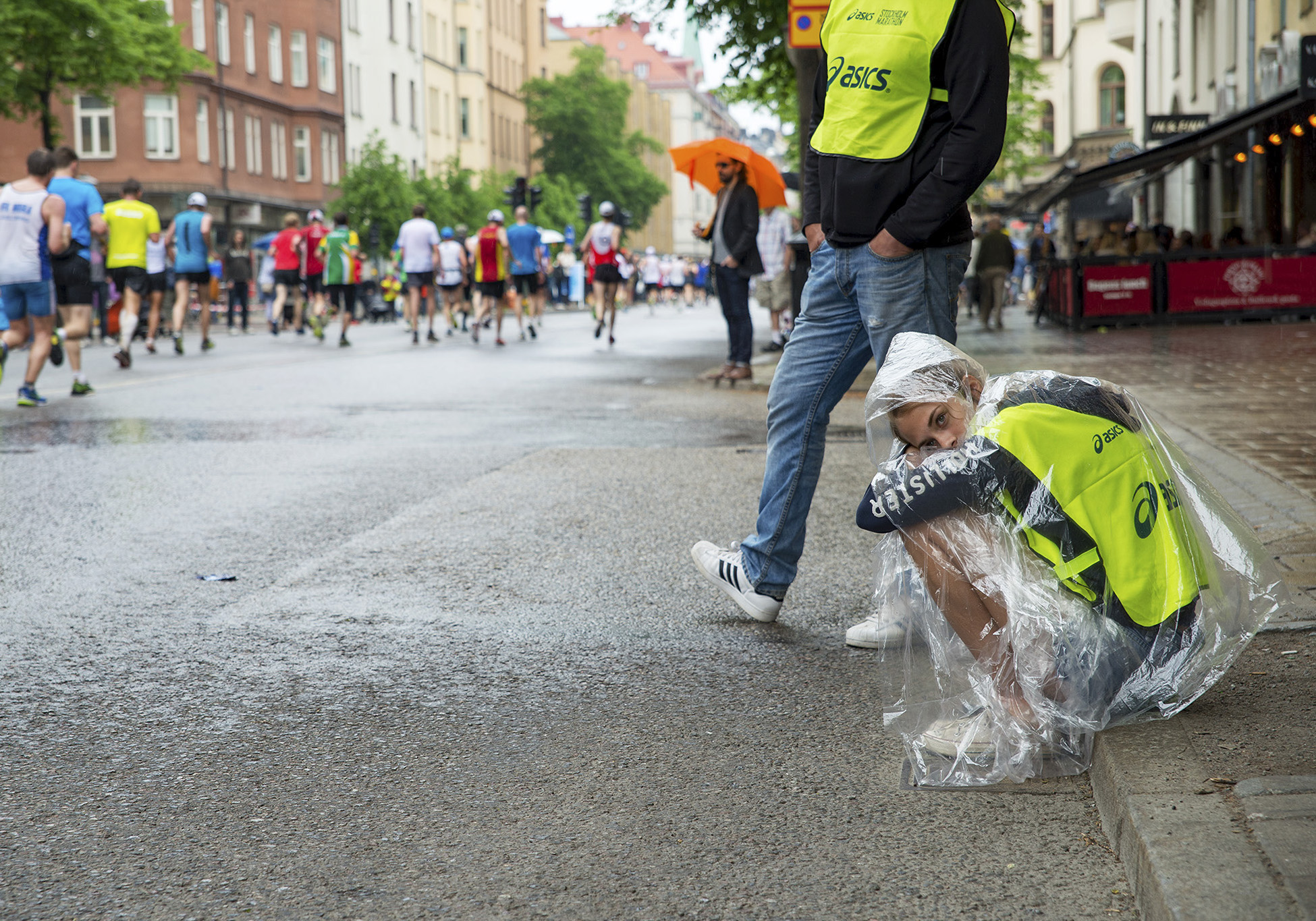 Uttråkad funktionär sitter på trottoarkanten